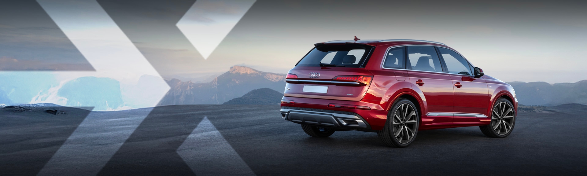 nexauto : Audi Q7 rouge vue de l'arrière droit, devant un décor montagneux avec une vue au loin.