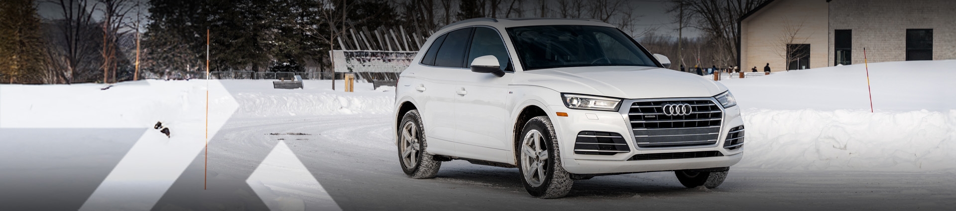 nexauto : Audi Q5 d'occasion blanche sur neige devant un bâtiment.