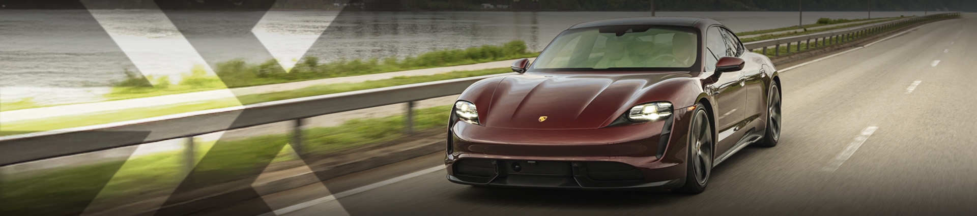 nexauto : Porsche Taycan d'occasion rouge devant le Fleuve Saint-Laurent.